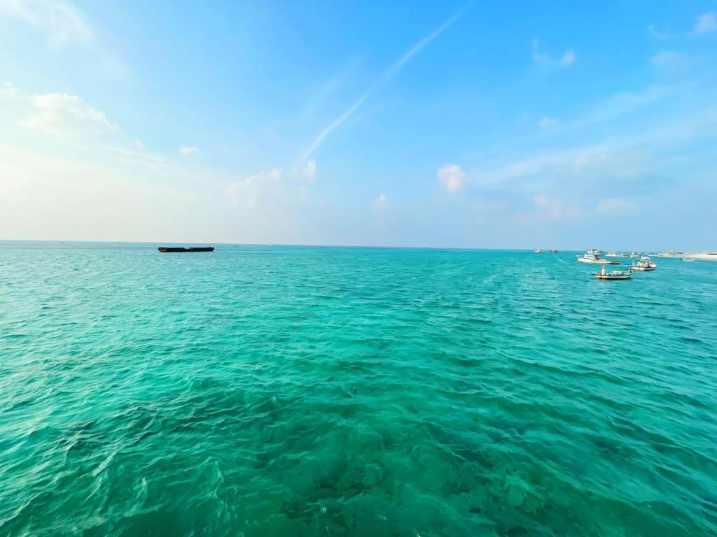 a large body of water with boats in it at Coral Paradise Beach Resort, Lakshadweep in Agatti