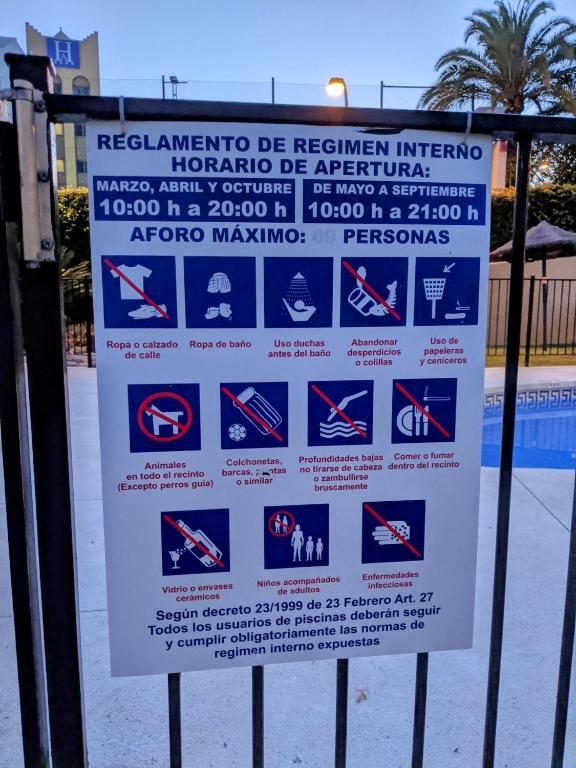 a sign on the side of a fence at Renovated apartment on beachside with pool in Nerja
