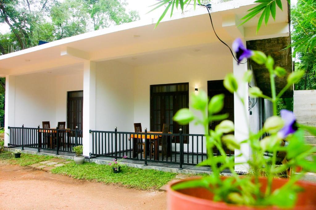 een huis met stoelen en een tafel ervoor bij Sigiri Heaven Villa in Sigiriya