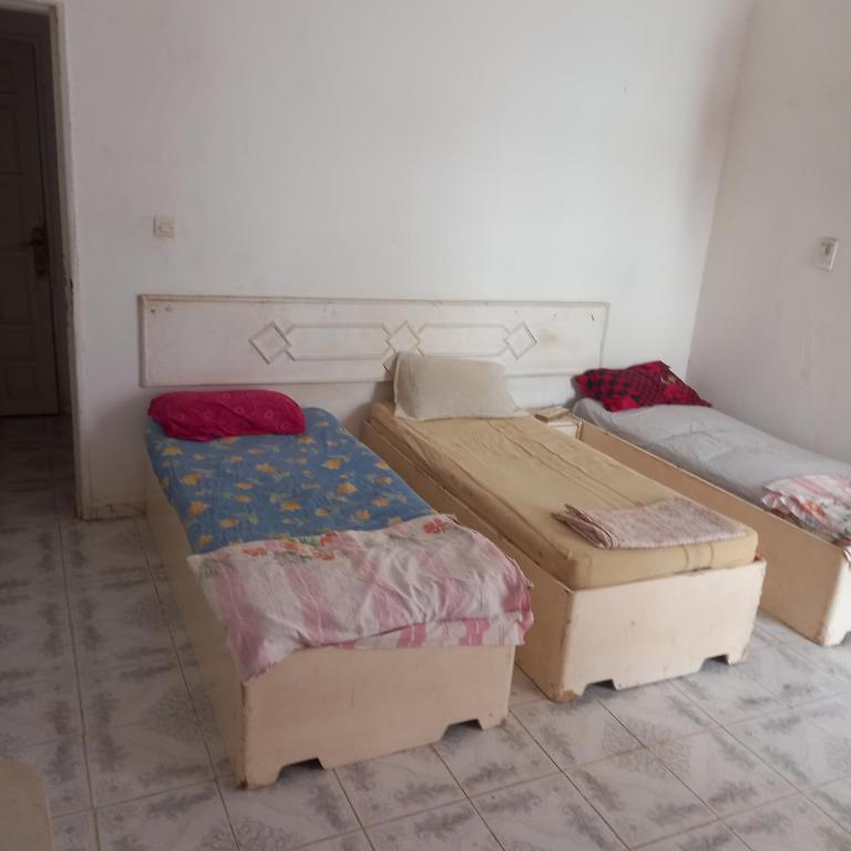 a room with three beds in a room at Lakhdar saaoudi in Nouakchott