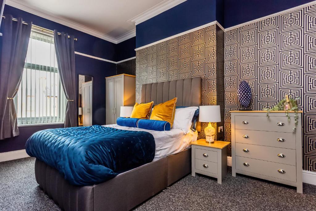 Schlafzimmer mit blauen Wänden, einem Bett und einer Kommode in der Unterkunft Room 03 - Sandhaven Rooms Double in South Shields