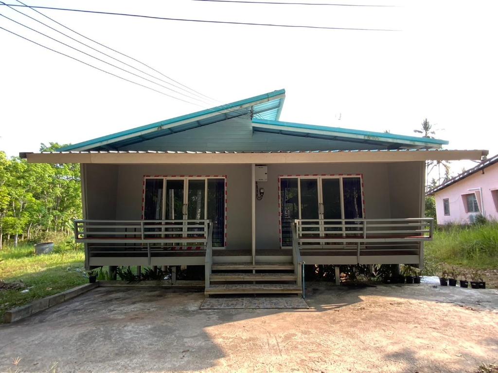 a small house with a porch at Firdous Guesthouse in Ban Khlong Hia