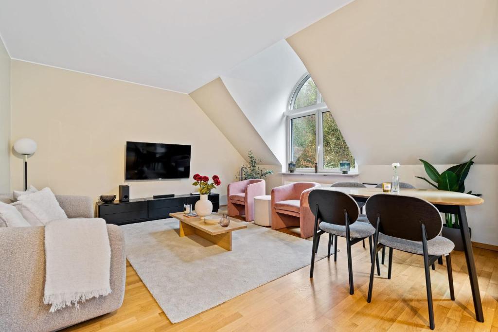 ein Wohnzimmer mit einem Sofa und einem Tisch in der Unterkunft Chic 2BR Beggen Apt: Comfort & Style in Luxemburg (Stadt)