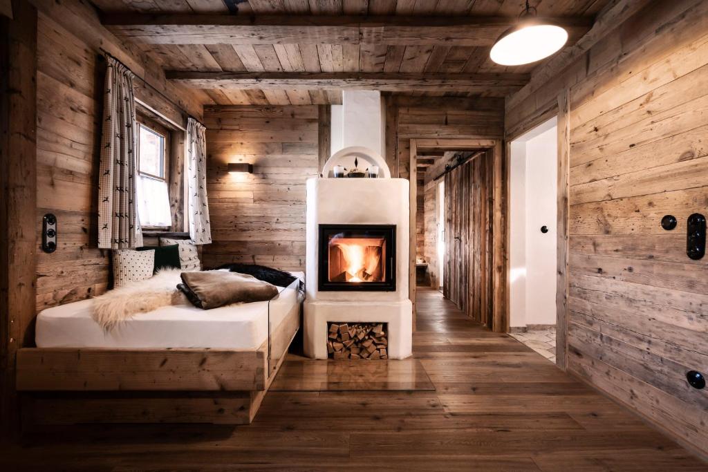 1 dormitorio con 1 cama con chimenea en Alpin Chalets Oberjoch - Luxus Unterkunft mit privatem SPA und Zugang zu 3000 qm SPA Panoramahotel Oberjoch en Bad Hindelang