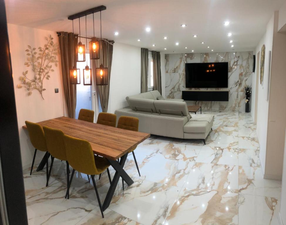 a living room with a marble floor and a table and chairs at Appartement RDC dans une Villas in Montpellier