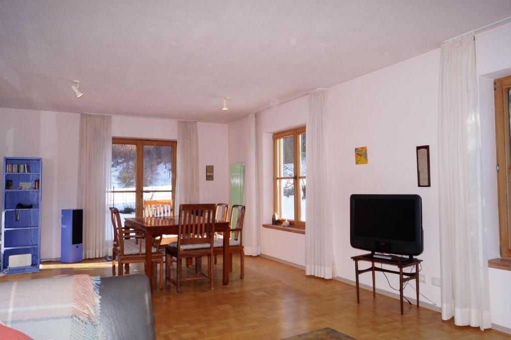 a living room with a table and a tv at Ferienhaus-Eschenlohe-Direkt-in-Bergnaehe-Wanderungen-und-Mountainbike-vom-Haus-aus-moeglich in Eschenlohe