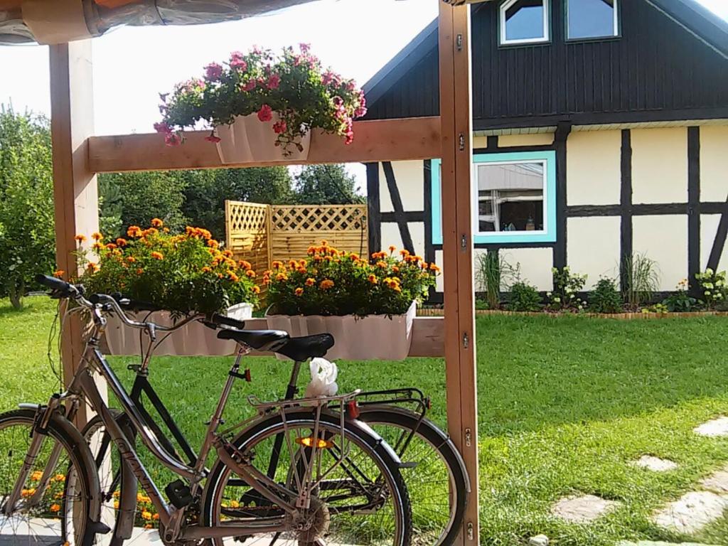 a bike parked in front of a house with flowers at Domki w Wytownie k. Ustki in Wytowno