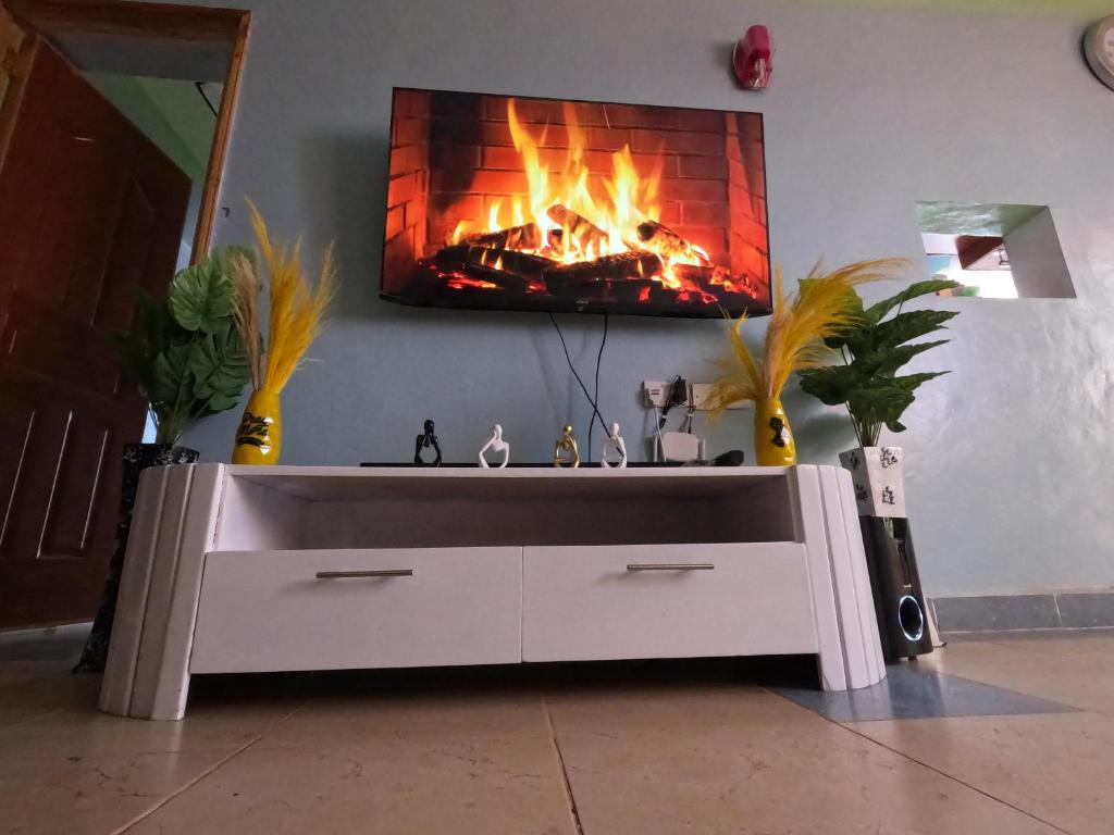 a living room with a fireplace in the wall at Nyeri Nest Retreat - One Bedroom in Nyeri
