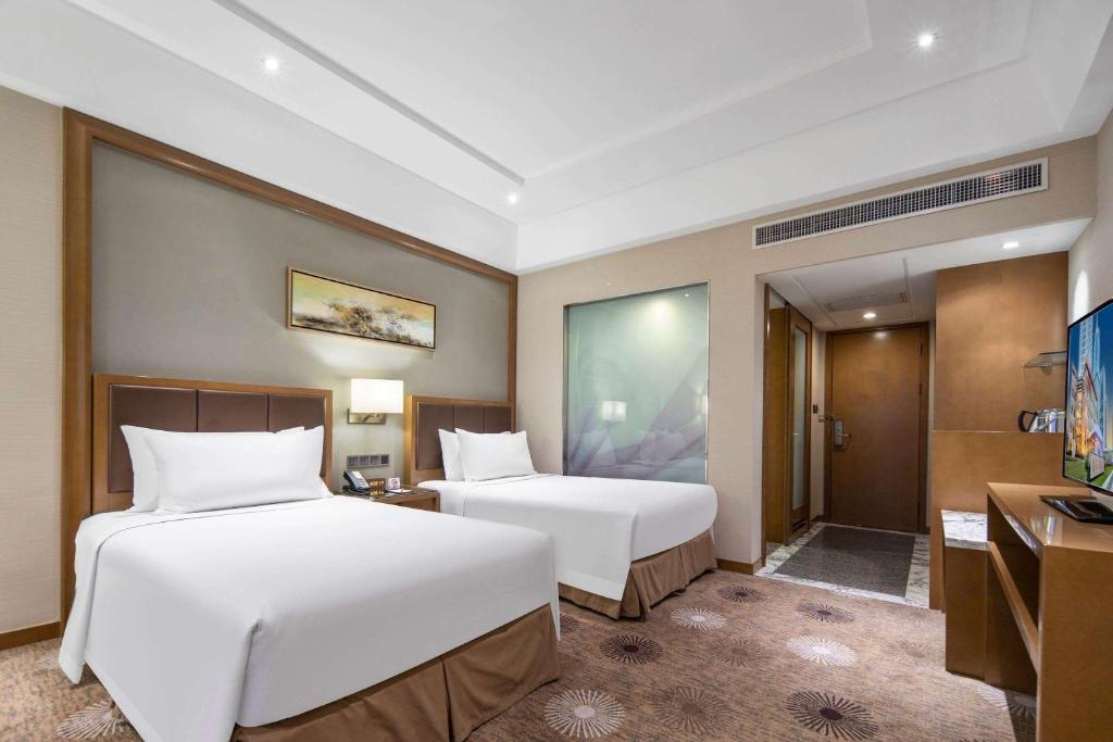 Postel nebo postele na pokoji v ubytování Ramada Plaza Pudong Shanghai