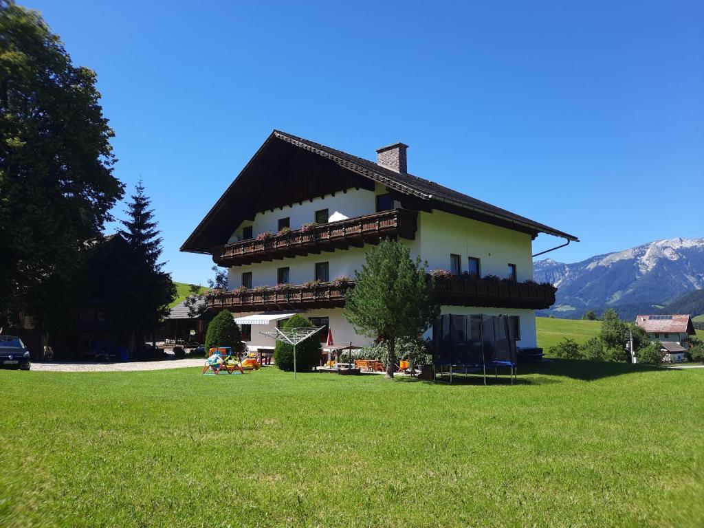 a house with a grassy field in front of it at Ferienhof Unterkotgraben in Spital am Pyhrn