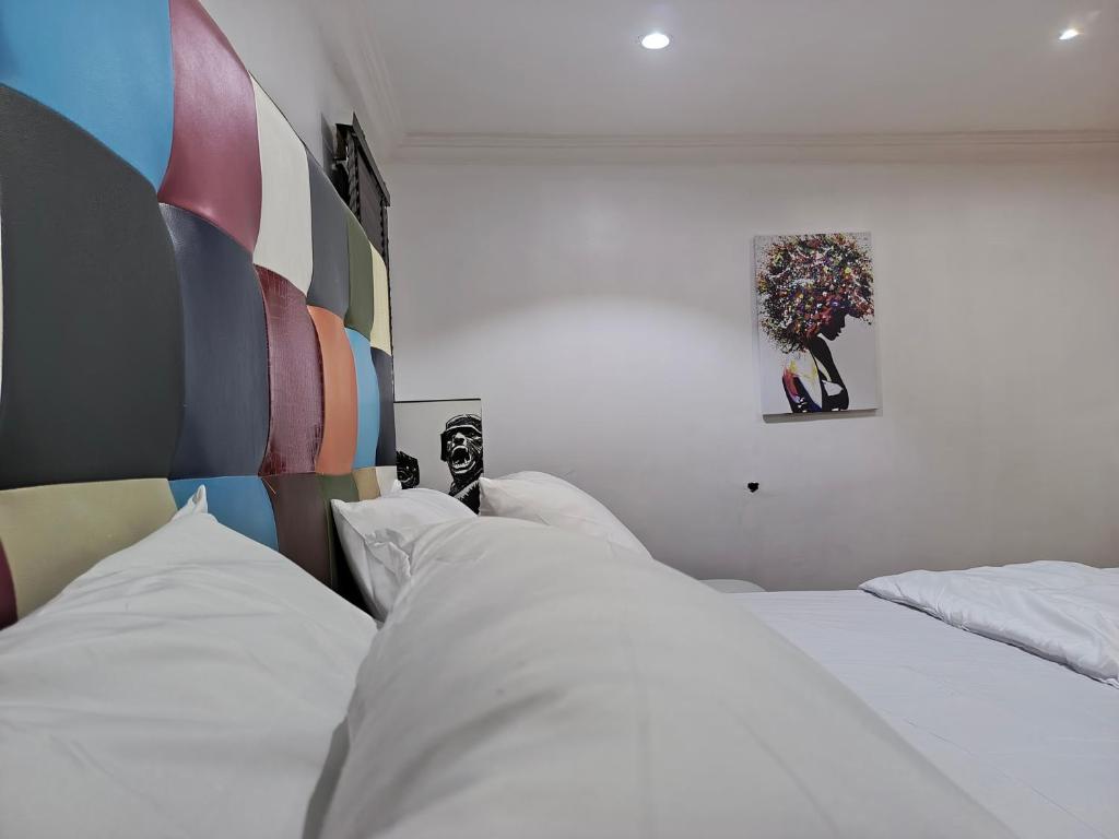 ラゴスにあるLovely 2-Bed House in Lagosのベッドルーム1室(ベッド2台付)が備わります。壁に絵が描かれています。