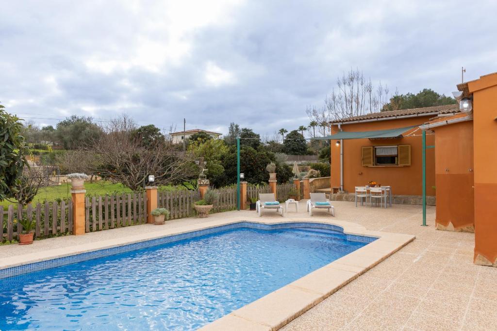 a swimming pool in a yard with a fence at Yourhouse Villa Sa Caseta in Llubí