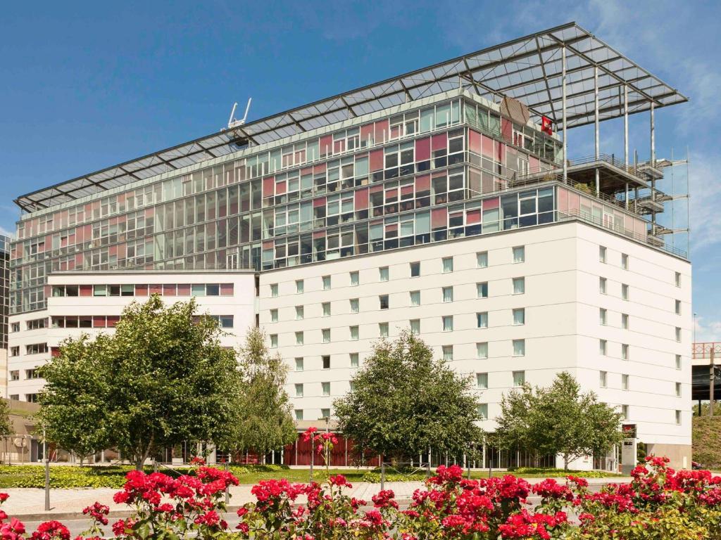 a large white building with a lot of windows at ibis Lyon Caluire Cité Internationale in Caluire-et-Cuire