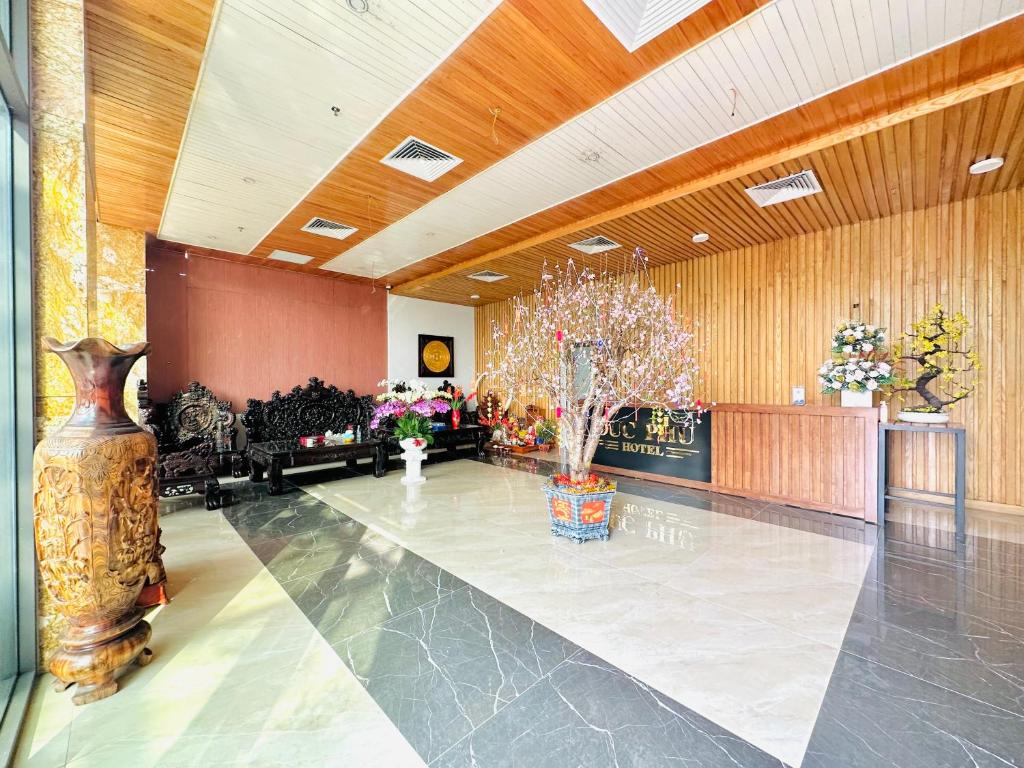 a lobby with a large room with vases on the floor at Khách Sạn Đức Phú in Bí Giàng