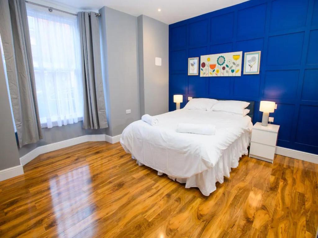 a bedroom with a large bed with blue walls at Pass the Keys Stonebow room at Tavmar Apartments in Lincoln