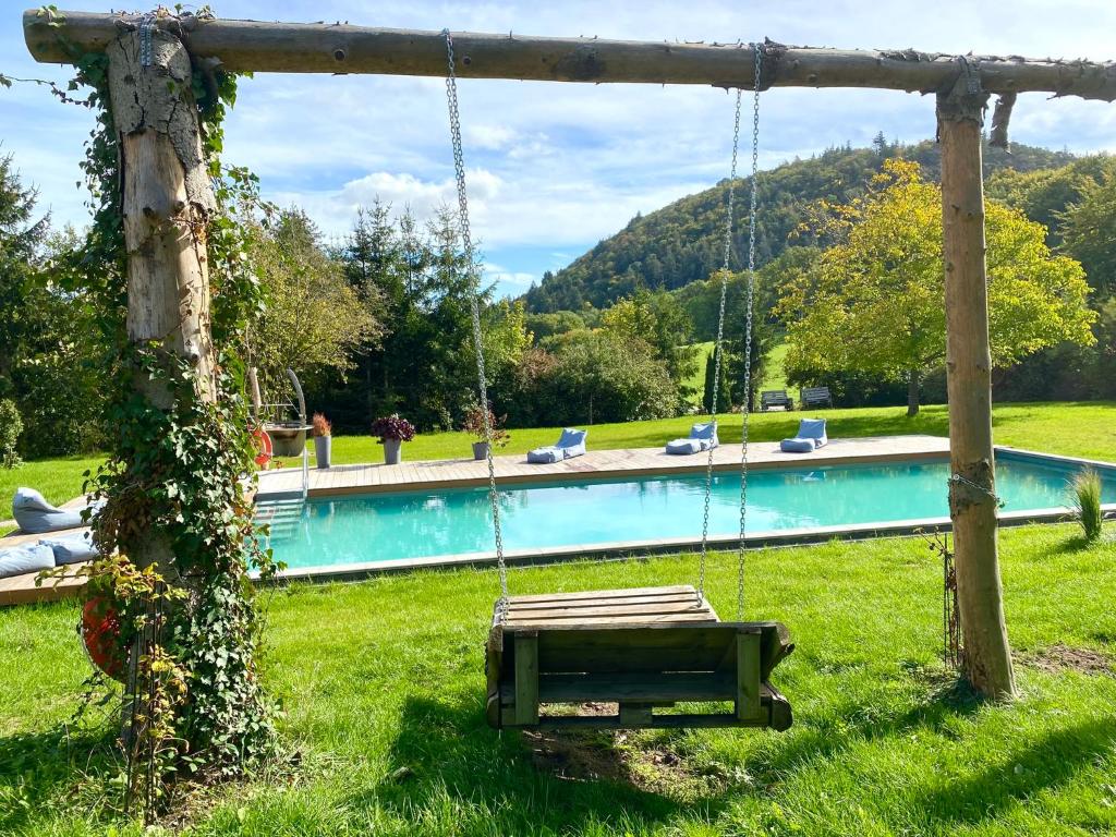 eine Schaukel in einem Garten neben einem Pool in der Unterkunft Hotel - Restaurant Bastenhaus in Dannenfels