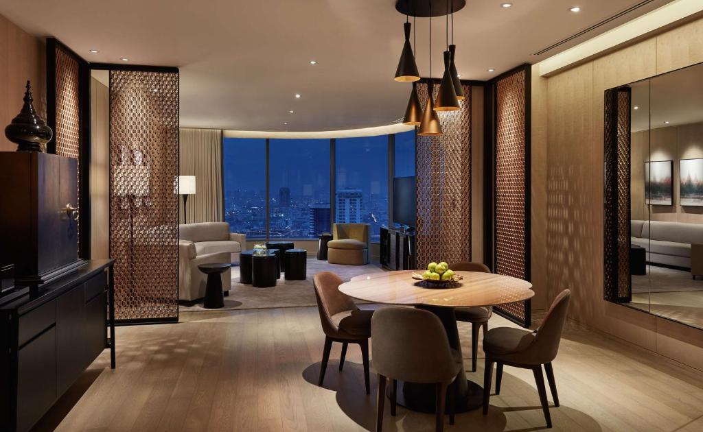 曼谷的住宿－Park Hyatt Bangkok，一间设有桌子的用餐室和一间享有美景的客厅