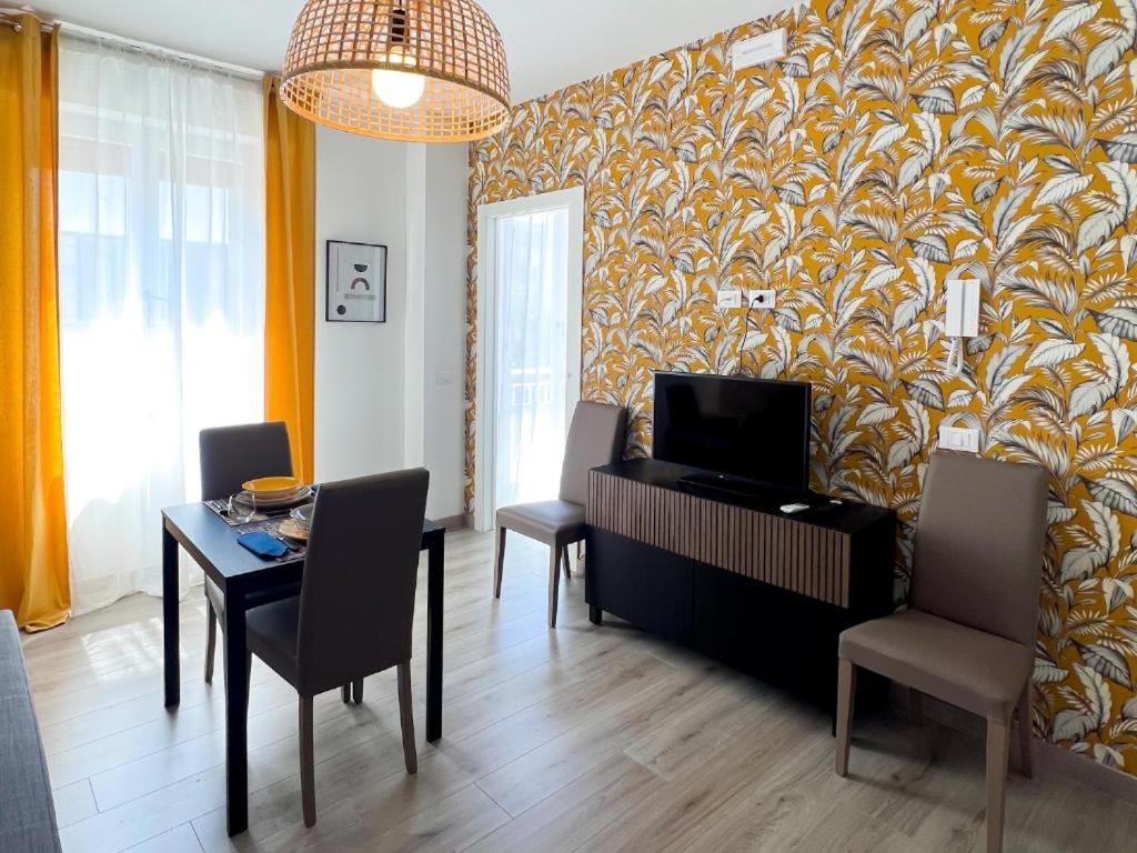 ein Wohnzimmer mit einem Tisch und Stühlen sowie einem TV in der Unterkunft SE048 - Marotta, nuovo bilocale fronte mare in Marotta
