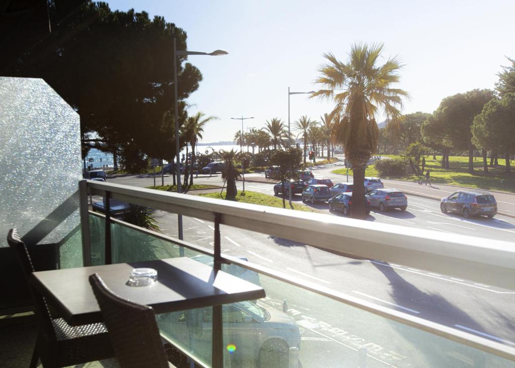 a balcony with a table and a view of a street at Tiercé Hotel in Cagnes-sur-Mer