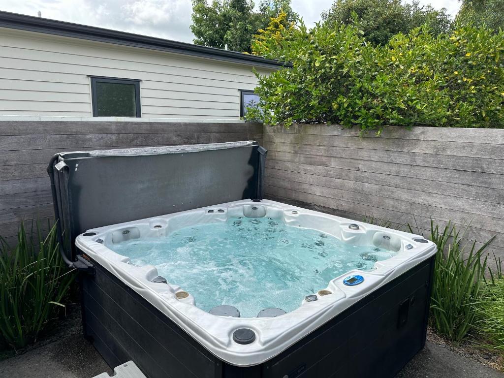 a large hot tub sitting in a backyard at Business or Holiday 4 bedrooms house in Hamilton with pool and spa in Hamilton