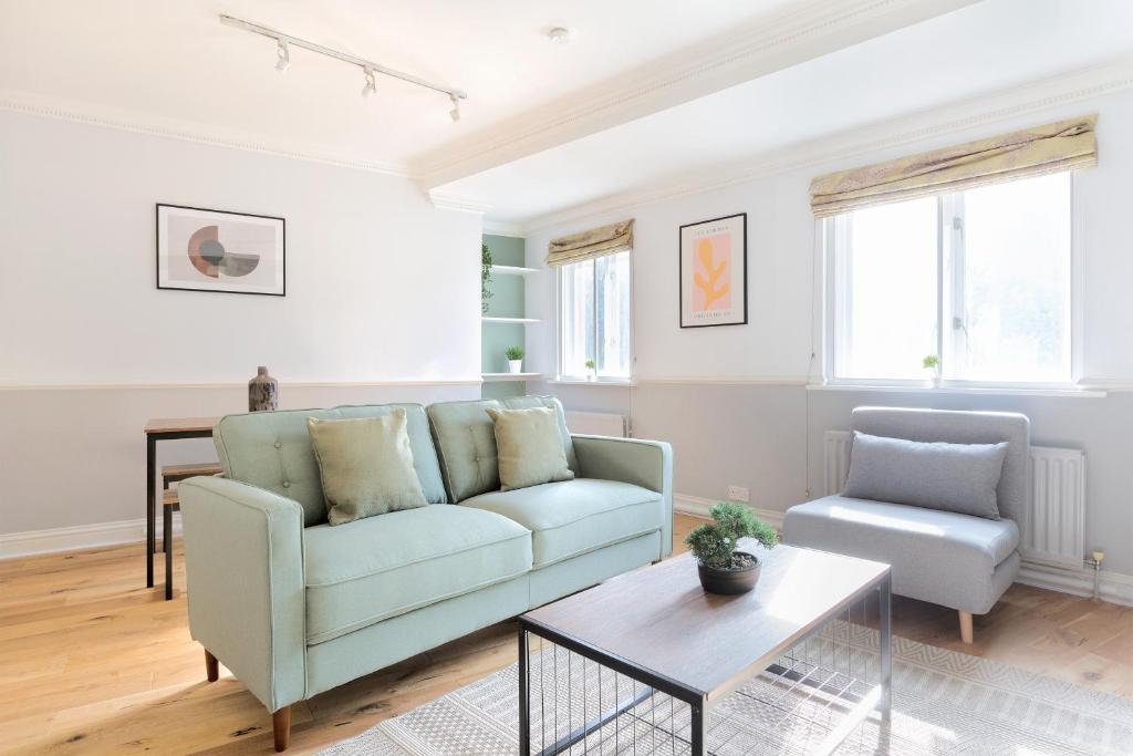ein Wohnzimmer mit einem Sofa und einem Tisch in der Unterkunft The Tower Bridge Apartment in London