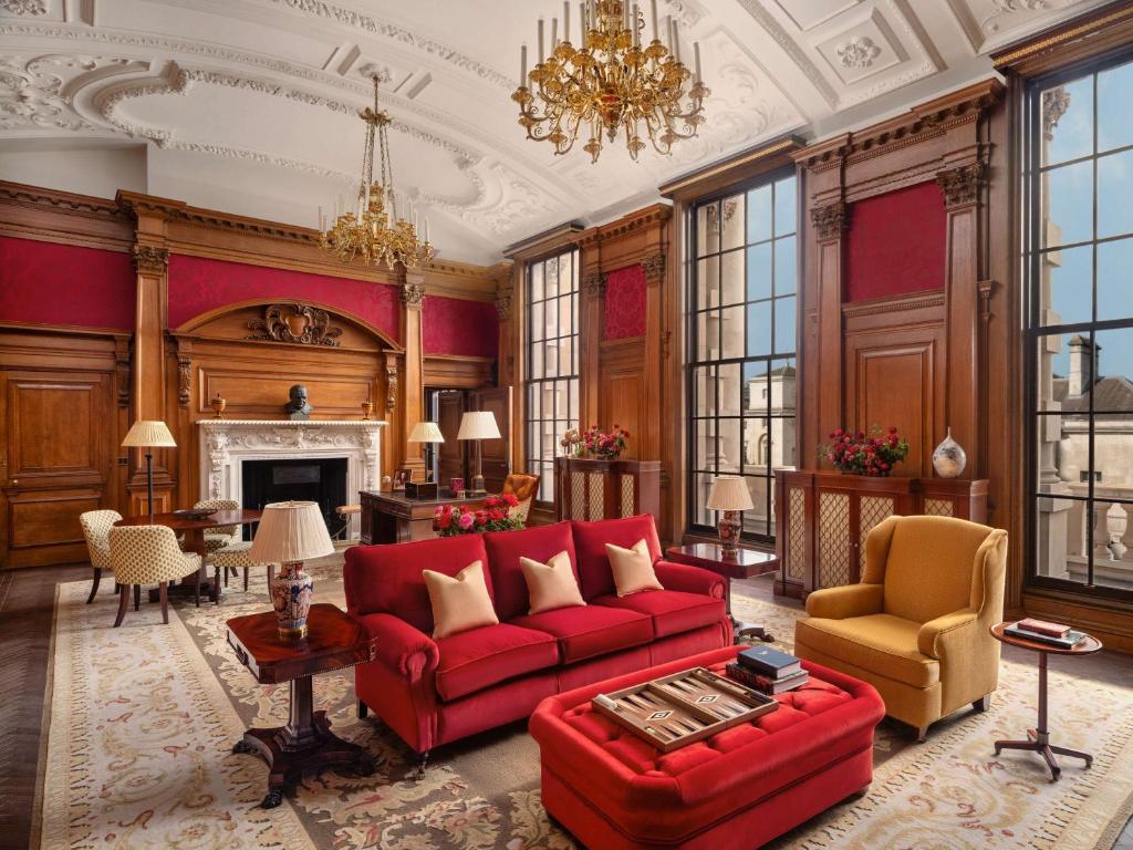 a living room with a red couch and a fireplace at Raffles London at The OWO in London