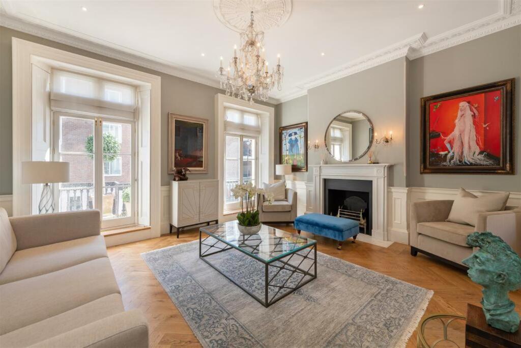 un salon avec un lustre et une cheminée dans l'établissement Prestige Belgravia Royal Mansion, à Londres