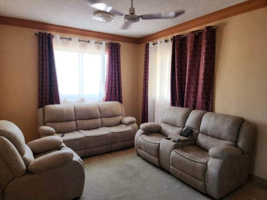 un soggiorno con divano, divano e sedia di Fair deal Apartment a Mombasa