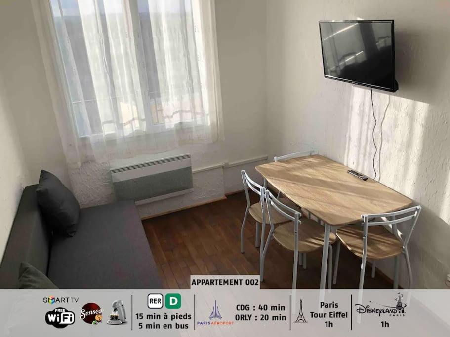 una pequeña sala de estar con mesa y TV en 40m² totalement rénovés belle vue dégagée (002), en Villeneuve-Saint-Georges