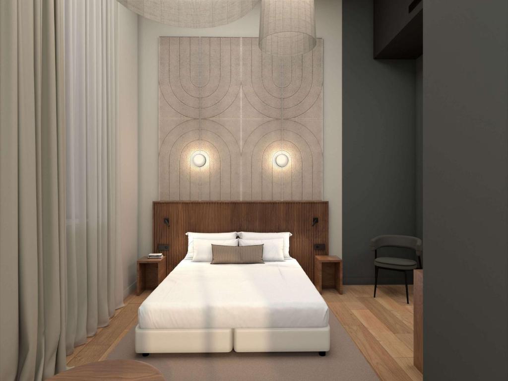um quarto com uma cama com uma colcha branca em Hotel et Spa Fort St Laurent Lyon - Handwritten Collection em Lyon