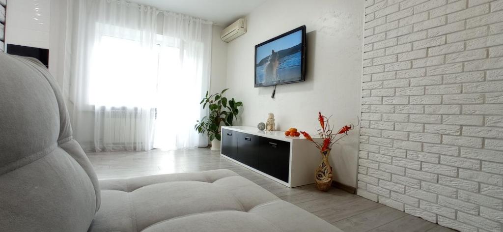 - un salon blanc avec une télévision sur un mur en briques blanches dans l'établissement ЖД Вокзал и Авто 1 кв Евро, à Dnipro