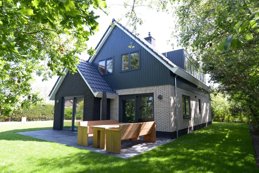 a house with a picnic table in the yard at Razende Bol in De Koog