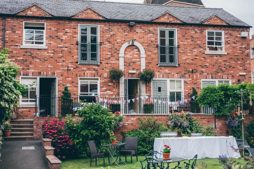 een stenen huis met een tafel ervoor bij Darwin's Townhouse in Shrewsbury