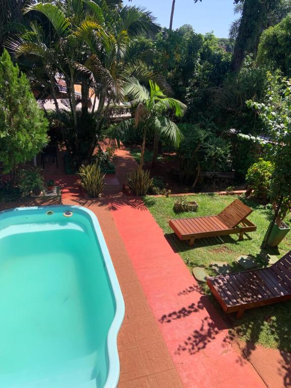 una piscina en un patio con una mesa de picnic y un banco en Ambar House Apart en Puerto Iguazú