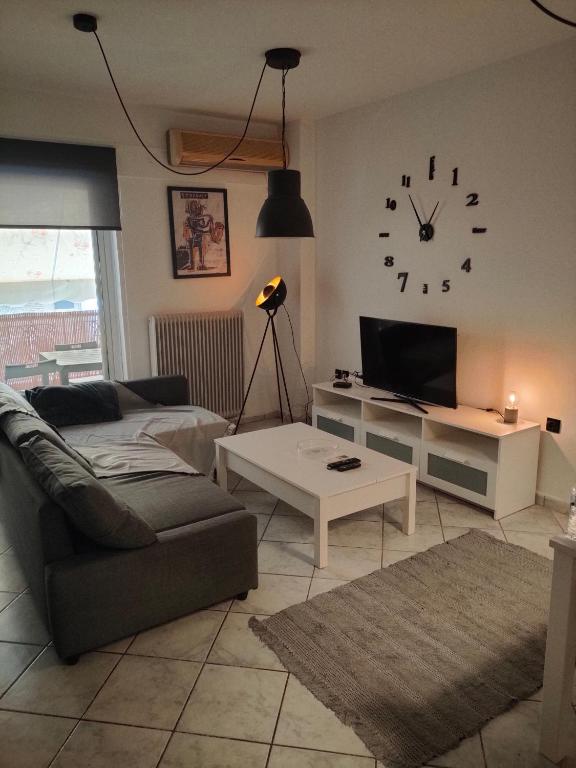 sala de estar con sofá y reloj en la pared en Makis 1, en Igoumenitsa