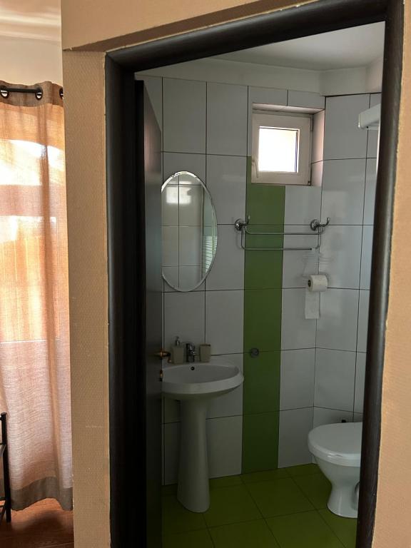 uma casa de banho com um lavatório, um espelho e um WC. em SIAN Sanctuary Villa em Braşov