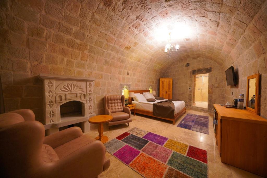 a living room with a bed and a fireplace at Secret Hill Cave Suites in Göreme