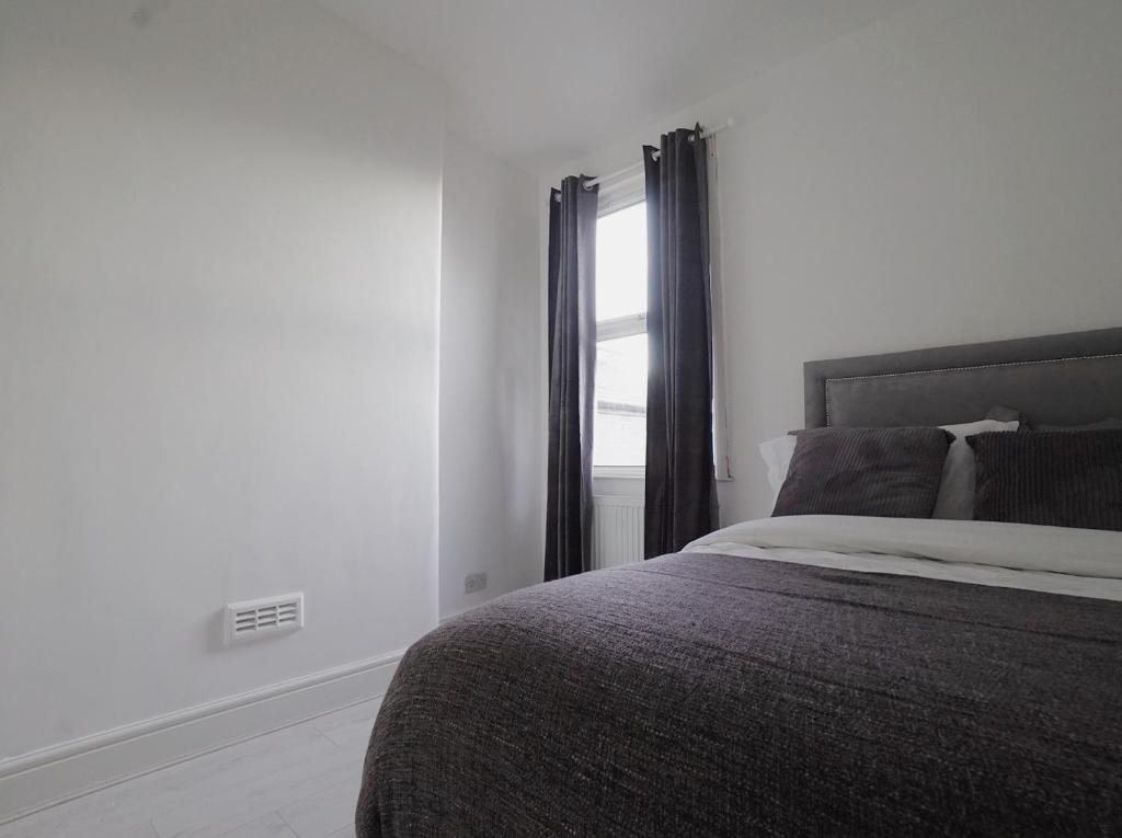 - une chambre avec un grand lit et une fenêtre dans l'établissement Milton Place, à Londres