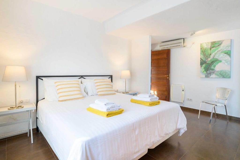 a bedroom with a white bed with two pillows at Villa Marisol, Los Mojones in Tías