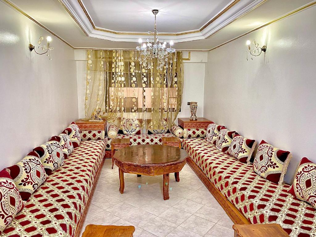 une salle d'attente avec des canapés, une table et un lustre dans l'établissement Appartement au cœur du ville, à Tanger