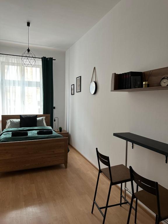 a bedroom with a bed and a table and chairs at Wielopole Classy Rooms in Krakow