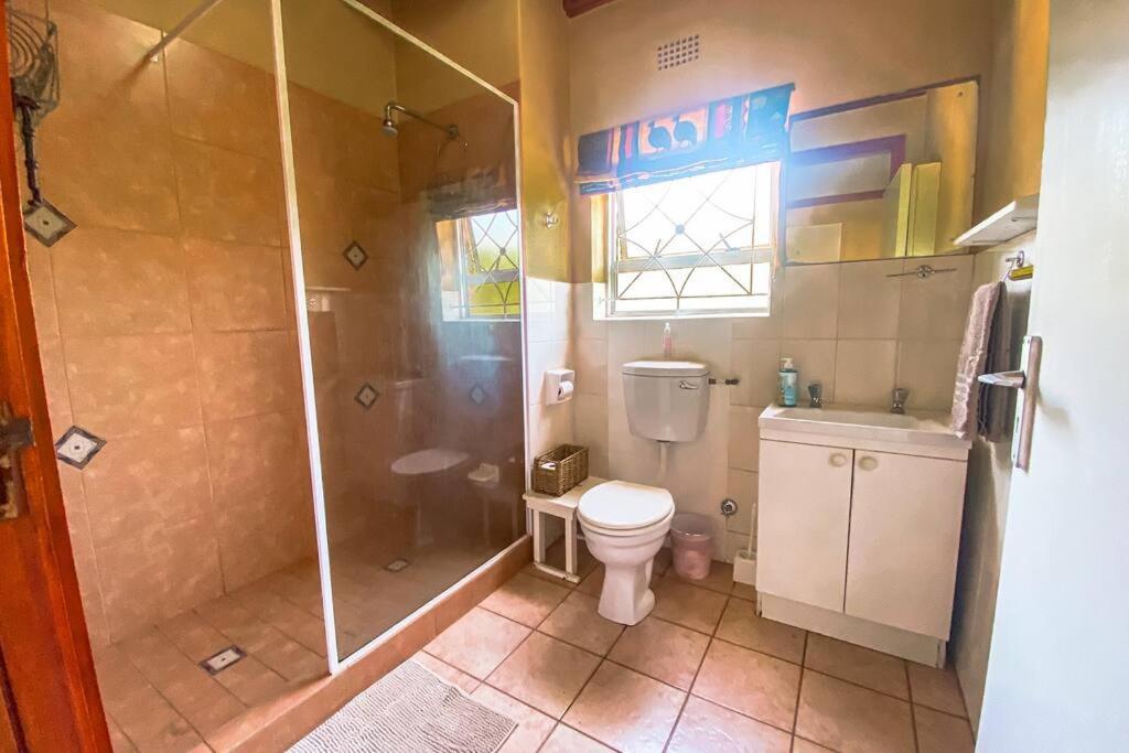 ein Badezimmer mit Dusche, Toilette und Waschbecken in der Unterkunft Family & pet friendly beach house, Kommetjie in Kapstadt