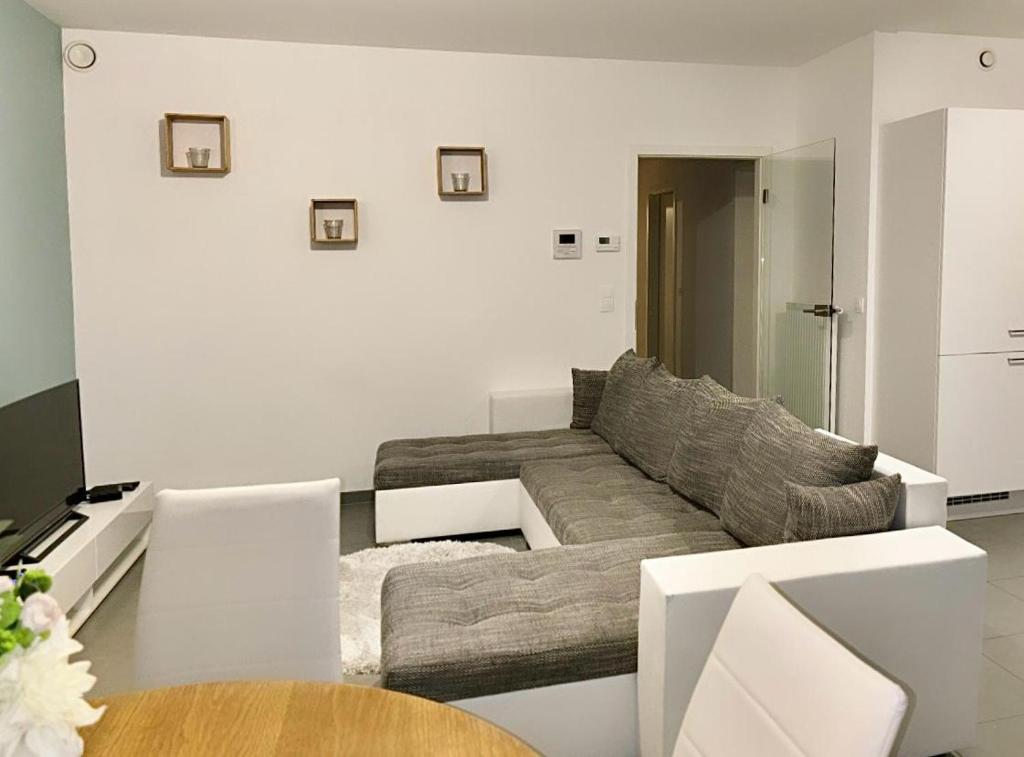 sala de estar con sofá y mesa en Magnifique appartement 2 chambres à Liège Ougrée en Seraing