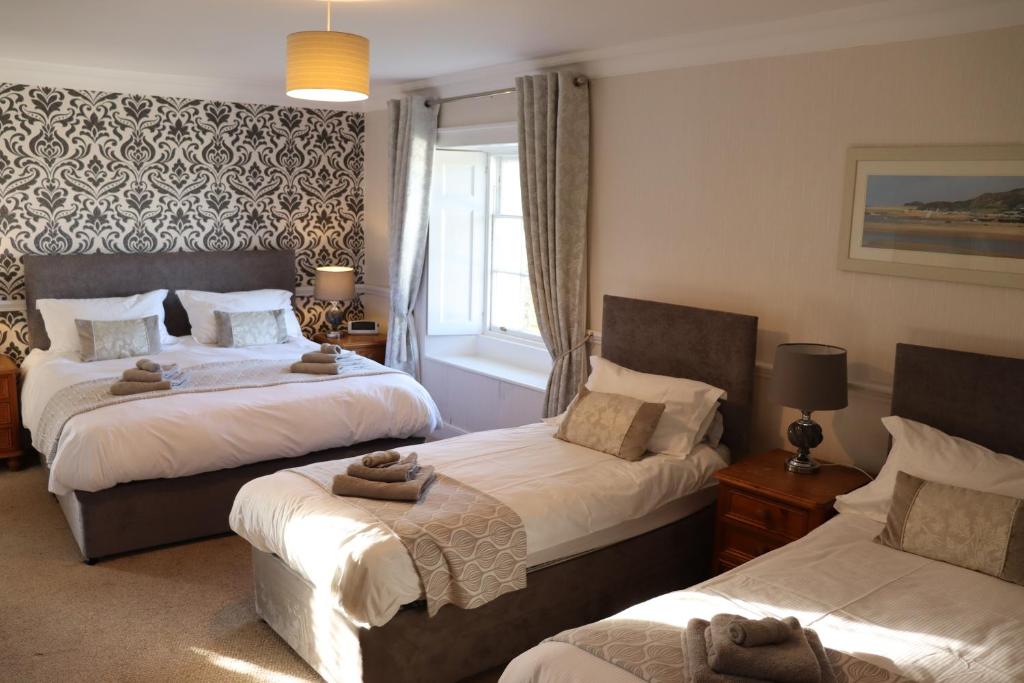 a bedroom with two beds and a window at Portclew House in Pembroke