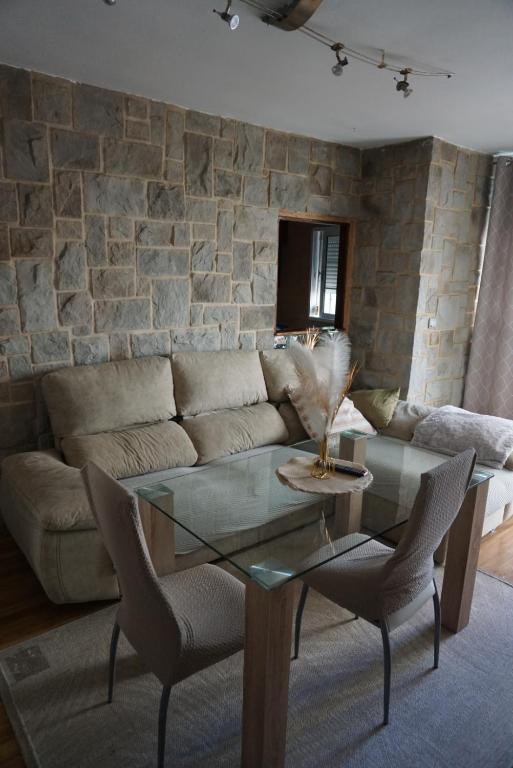 Apartamento en Huelva. في هويلفا: غرفة معيشة مع أريكة وطاولة زجاجية