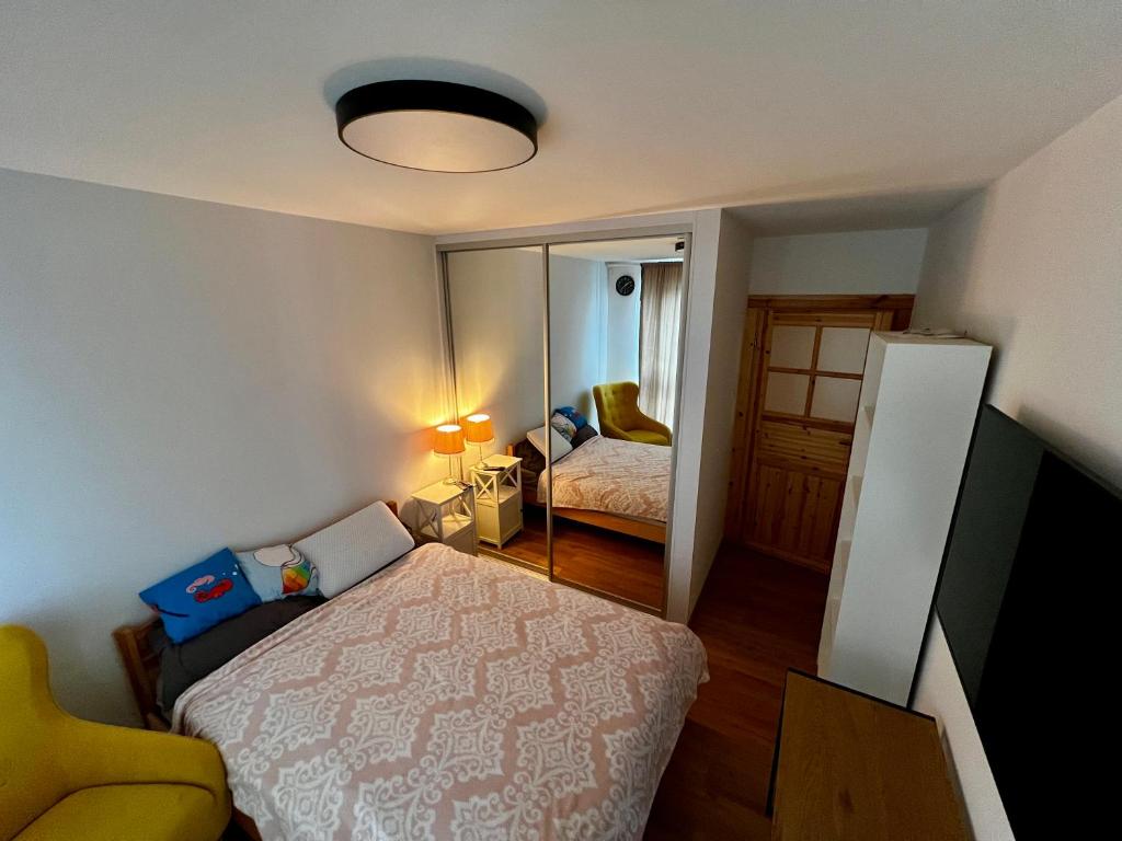 Dormitorio pequeño con cama y espejo en Granata Apartments, en Lublin