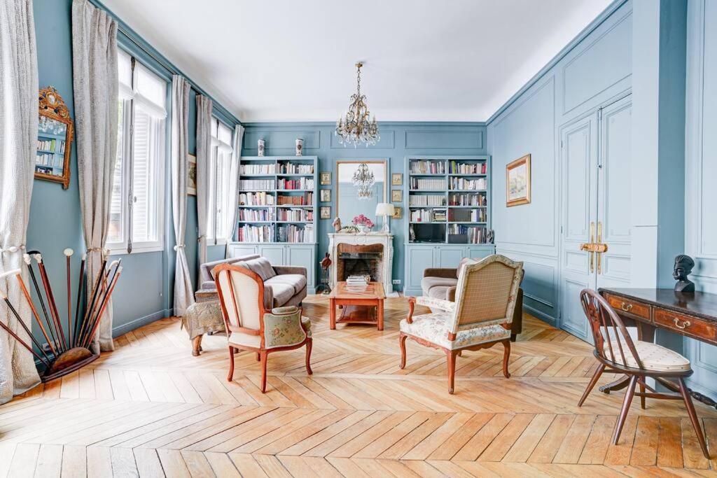 salon z niebieskimi ścianami i krzesłami w obiekcie Au pied de la tour Eiffel w Paryżu
