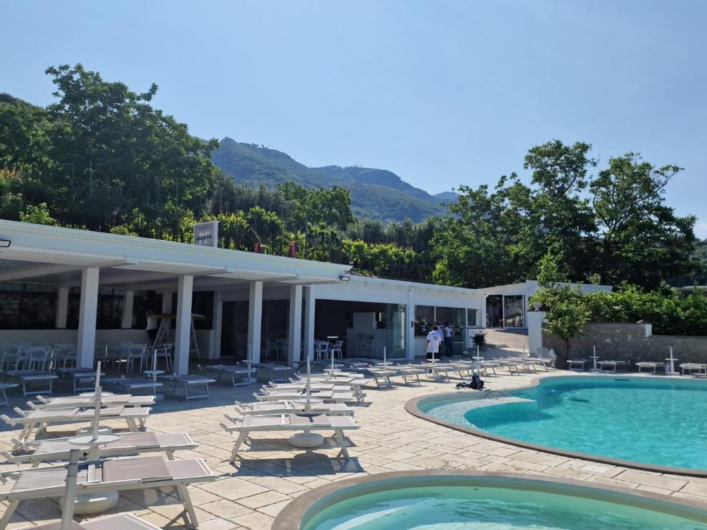 un resort con piscina e sedie a sdraio di Agriturismo Nonno Luigino a Vico Equense