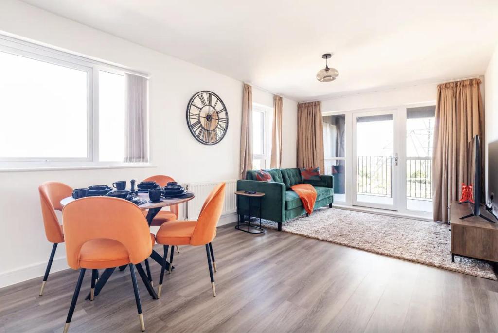 een woonkamer met een tafel en stoelen bij Luxury Modern 2 Bed Apartment in Ebbsfleet - 20mins from London in Swanscombe