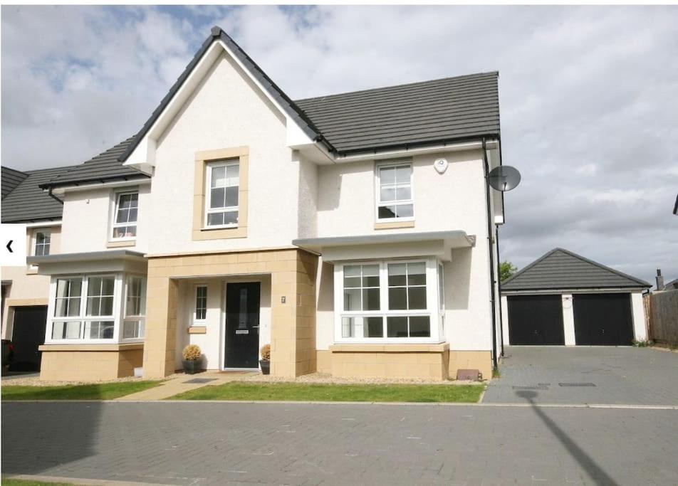 una casa blanca con techo negro en Luxury Detached Home en Edimburgo